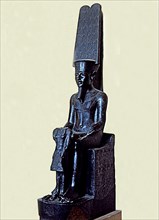 Statue of the god Amon protecting Tutankhamen, made in black granite, 1350 b.C., partially destro?