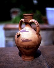 Earthenware pitcher decorated with blue and red details.