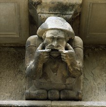 Façade of the Paeria of Cervera, anthropomorphic corbel of a personage sick of the teeth showing ?