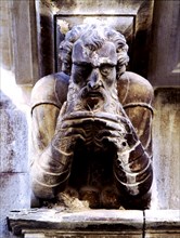 Façade of the Paeria of Cervera, anthropomorphic corbel of a personage stroking his beard.