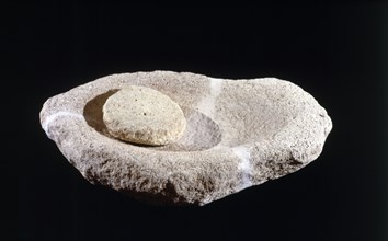 Hand mill from the Cova de l'Or (Beniarres, Alicante). Made of sandstone, length of 50 cm.