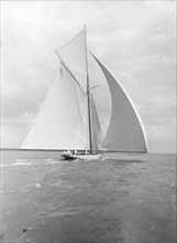'Istria' sailing downwind under spinnaker, viewed from stern, 1912.  Creator: Kirk & Sons of Cowes.