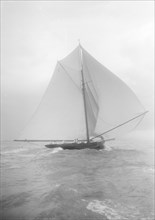 The gaff rigged cutter 'Bloodhound' sailing downwind under spinnaker, August 1912. Creator: Kirk & Sons of Cowes.