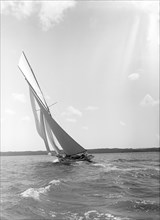 A 15 Metre yacht sailing close-hauled in a good breeze, 1911. Creator: Kirk & Sons of Cowes.