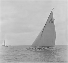 The 6 Metre class 'Freesia' sailing close-hauled, 1921. Creator: Kirk & Sons of Cowes.