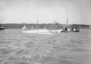 The dismasted sailing yacht 'Clio' is attended to by rescue boats, 1912. Creator: Kirk & Sons of Cowes.