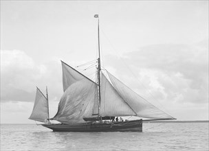 The yawl 'Roma' raising main sail, 1912. Creator: Kirk & Sons of Cowes.