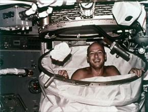 Conrad in shower facility aboard Skylab 2, 1973. Creator: NASA.