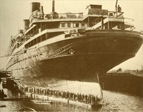Cleaning the Hull of the "Majestic" in Dry Dock', c1930.
