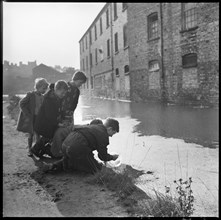 Children using a goldfish bowl to fish in the Caldon Canal, Hanley, Stoke-on-Trent, 1965-1968