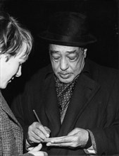 Duke Ellington signing his autograph, c1962.