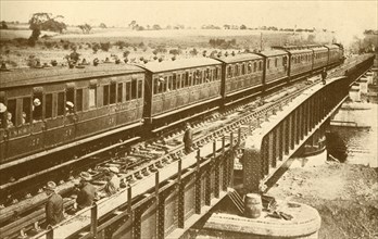 A Train Passing Over The Bridge', c1930.