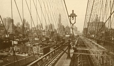 Lower Manhattan Viewed Through The Network Of Cables On Brooklyn Suspension Bridge', c1930.