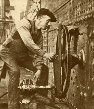 A Pneumatic Riveter Cutting Portholes in the Side of a Liner', c1930.