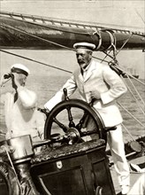 King George V at the wheel of of his yacht, Britannia