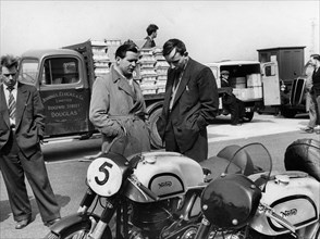 John Surtees with Nortons in paddock at 1954 Isle of Man T.T.. Creator: Unknown.