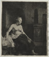 Woman Sitting Half Dressed Beside a Stove, 1658. Creator: Rembrandt van Rijn (Dutch, 1606-1669).