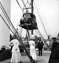 1910 Mercedes being craned onboard ship. Creator: Unknown.