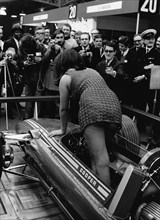 Female model climing in to Cooper F5000 at 1969 Racing Car show. Creator: Unknown.