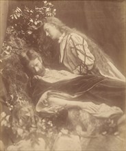 Gareth and Lynette, 1874. A bearded man (Andrew Hichens) poses as Gareth reclining with head cast down and eyes closed. A woman (May Prinsep Hichens), poses as Lynette, standing and leaning above him ...