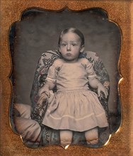 Child Sitting on Chair Draped with Floral Print Fabric, 1850s.
