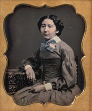 Seated Young Woman Wearing Collar with Large Bow, Resting Arm on Table, 1850s.