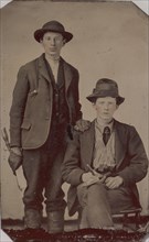 Two Young Men, One Seated and One Standing, Holding Carpentry Tools, 1870s-90s.