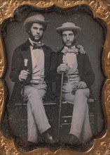 Two Seated Young Men Holding Ivory-topped Walking Sticks, 1850s.