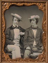 Two Seated Young Men Wearing Gingham Trousers, Bow Ties, and Brimmed, Soft Hats, 1850s.
