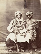 Turbaned Man Holding Rifle with Boy Alongside, 1860s.