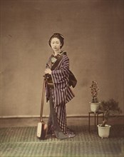 [Japanese Woman in Traditional Dress Posing with Instrument], 1870s.