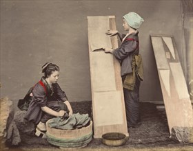 [Two Japanese Women Posing with Laundry], 1870s.
