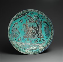 Bowl with a Majlis Scene by a Pond, Iran, dated A.H. 582/ A.D. 1186. Abu Zayd, a proficient poet, composed at least one of the love poems inscribed on this bowl.