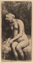 Nude Seated on a Bench with a Pillow (Woman Bathing Her Feet at a Brook), 1658.