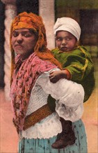 Mother and child, Tangier, 1932. Moroccan woman carrying her baby.