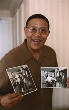 Bob Cranshaw, Swinging Jazz Party, Blackpool, 2005; backstage holding photos of the Junior Mance Trio taken by Brian Foskett.