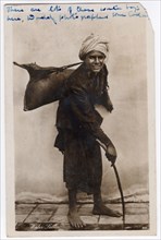 Water seller, Egypt, 1930s. Man carrying water in a container made of a sheep or goat skin.