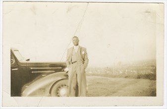 Photograph of an unidentified man in front of car, ca. 1920. Creator: Unknown.