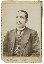 Photograph of a man wearing a dark colored suit with a pocket watch in his vest, 1886-1900. Creator: W. M. Hubbard.