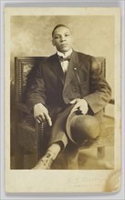 Photographic postcard of a seated man holding a bowler hat, 1904-1918. Creator: Unknown.