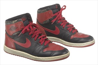 Pair of red and black Air Jordan I high top sneakers made by Nike, 1985. Creator: Nike.