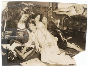 Photographic print of 4 women sitting in front of a sofa, early 20th century. Creator: Unknown.