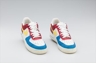 Red, white, yellow, and blue Nike sneakers worn by Big Boi of Outkast, 2005-2006. Creator: Nike.