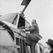 P.A. Gaglardi, Minister of Highways for British Columbia, climbing into a helicopter, M1, 22/5/1959. Creator: John Laing plc.