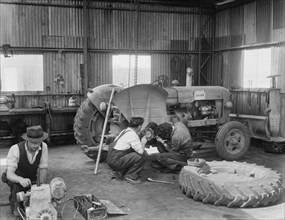 Laing workers carrying out maintenance work on the a Fordson Major Diesel Tractor, 22/07/1959. Creator: John Laing plc.