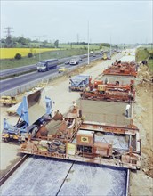 Slipform paving machines laying a road surface during widening works on the M1, 18/05/1982. Creator: John Laing plc.