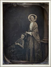 Untitled (A Woman in Bonnet and Shawl, with her Seated Son), c. 1850. Creators: Albert Sands Southworth, Josiah Johnson Hawes.