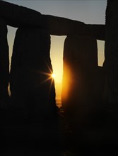 View of Stonehenge, showing the sun's rays glinting through the opening in a trilithon, 2012. Creator: James O Davies.