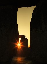 General view of Stonehenge, showing the rays of the rising sun shining through the openings in trilithons, 2012.