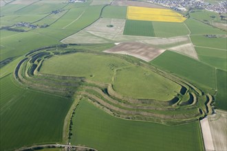 Maiden Castle, known primarily as an Iron Age multivallate hillfort earthwork, but also contains a Neolithic causewayed enclosure earthwork and long mound earthwork, and the remains of a Roman temple,...